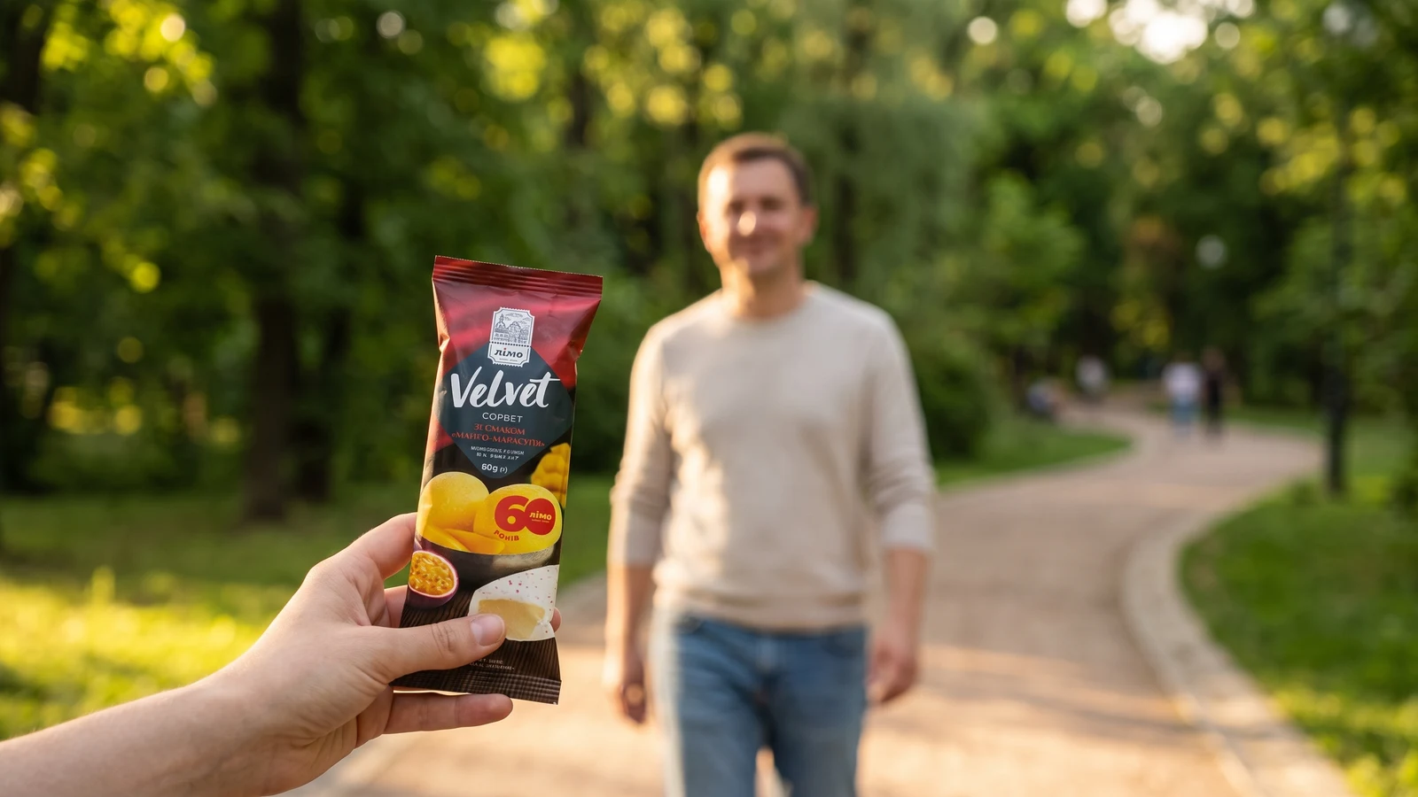 Persona caminando en el parque disfrutando de un sorbete de frutas Gelimo Línea Fit como pausa liviana