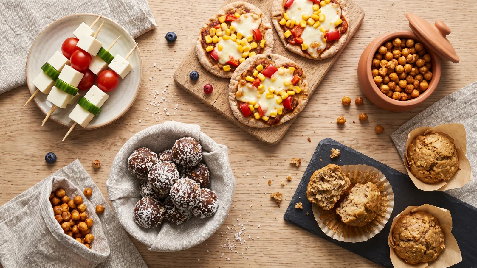 Distintas ideas de meriendas escolares saludables: mini pizzas, pinchos, muffins y bolitas energéticas
