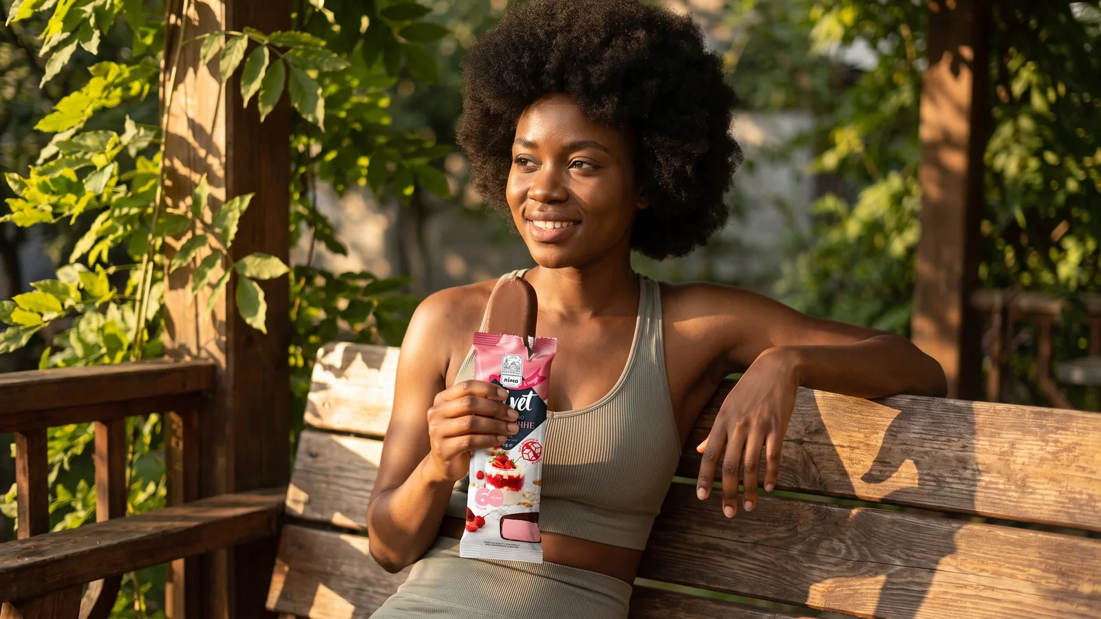 Mulher negra desfrutando de Gelimo como parte de um momento equilibrado após uma rotina ativa