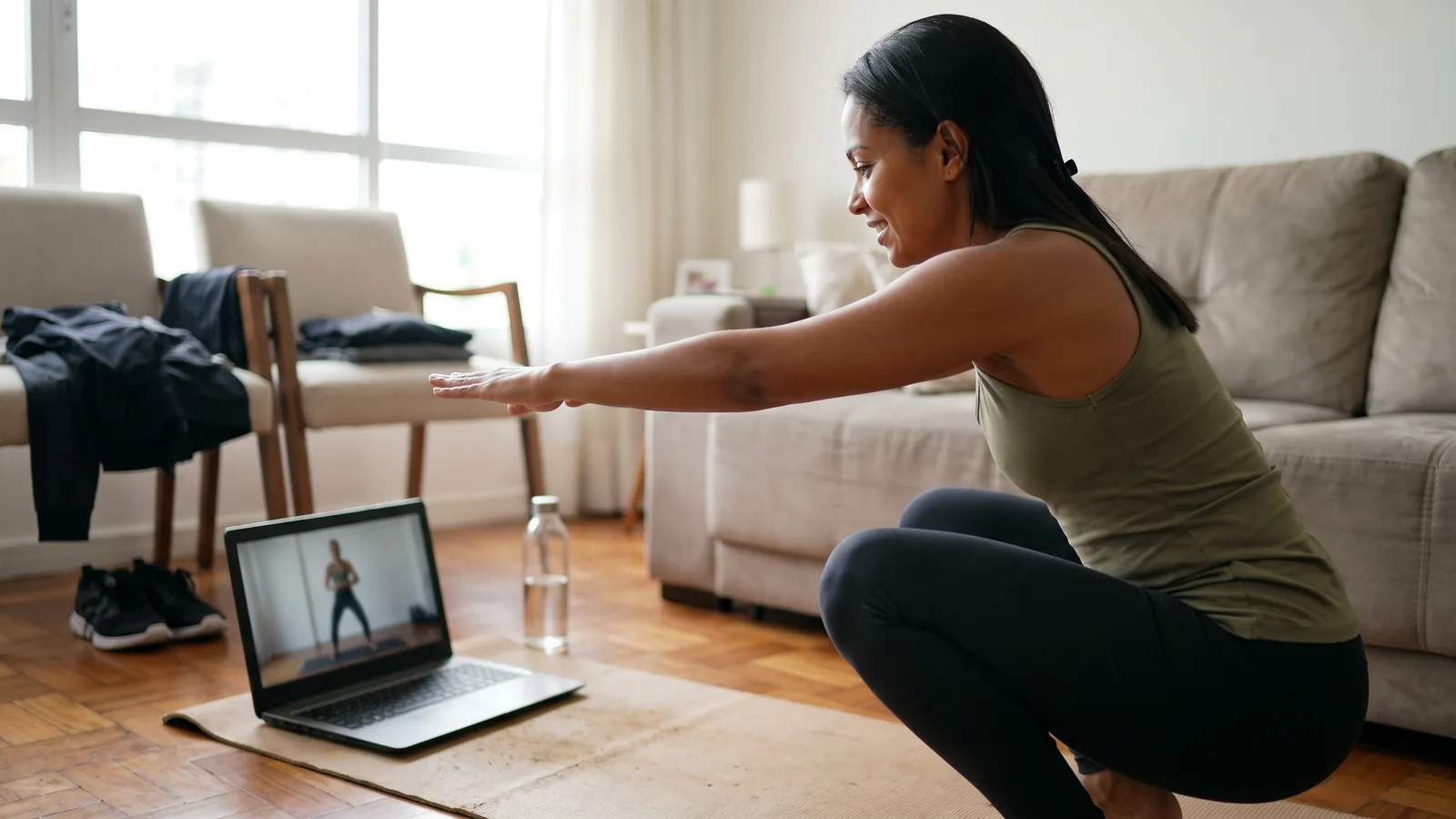 Pessoa fazendo uma sessão curta de exercícios em casa com uma aula online.